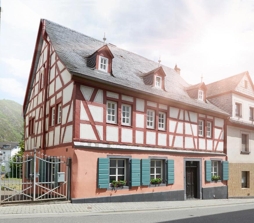 a red and white building with blue shutters at Ferienhaus Apple Tree in Treis-Karden