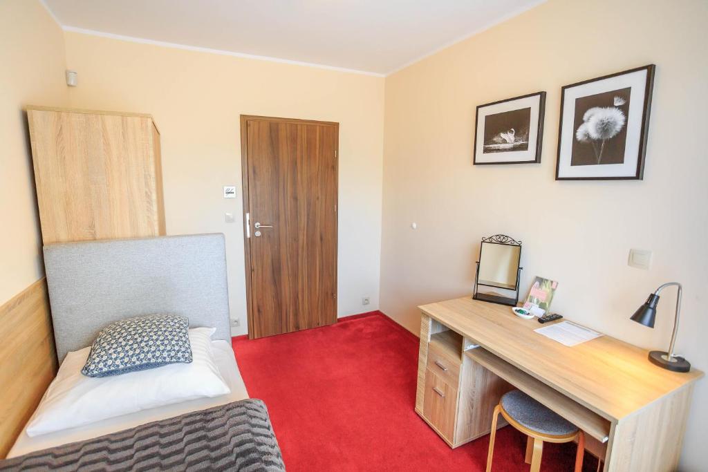 a bedroom with a desk and a bed and a desk at Botanik Hostel in Poznań