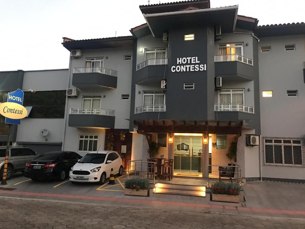 a hotel with a car parked in a parking lot at Hotel Contessi in Urussanga