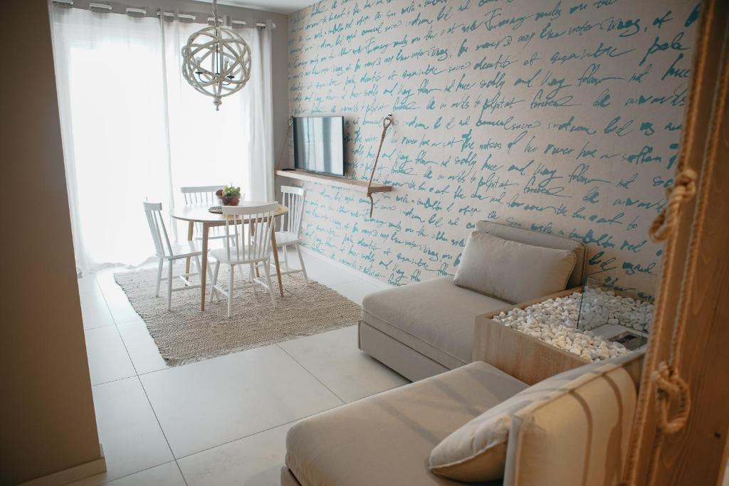 a living room with a couch and a wall with writing at Terradamare in Monopoli