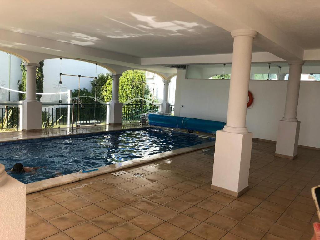 a swimming pool in a house with columns at Edificio Magnolia in Guia