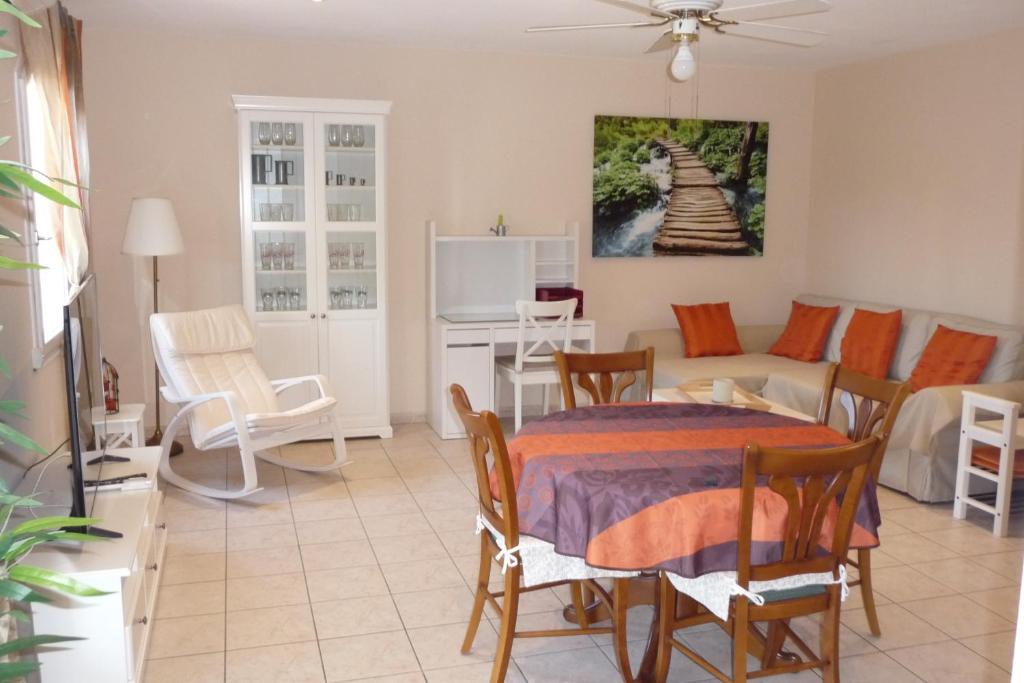 a dining room and living room with a table and chairs at charmante villa individuelle proche de la mer in Bormes-les-Mimosas