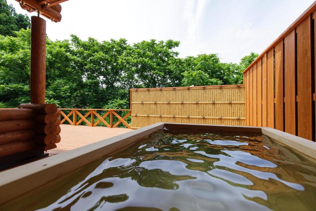 a pool of water in a backyard with a wooden fence at Natural Retreat Mountain Blue / Vacation STAY 2336 in Hakusan
