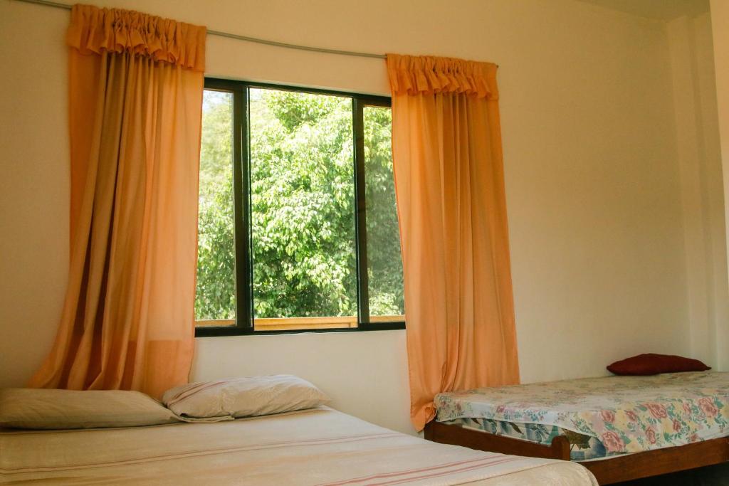 1 dormitorio con 2 camas y ventana grande en Hospedaje Costa Norte, en Máncora
