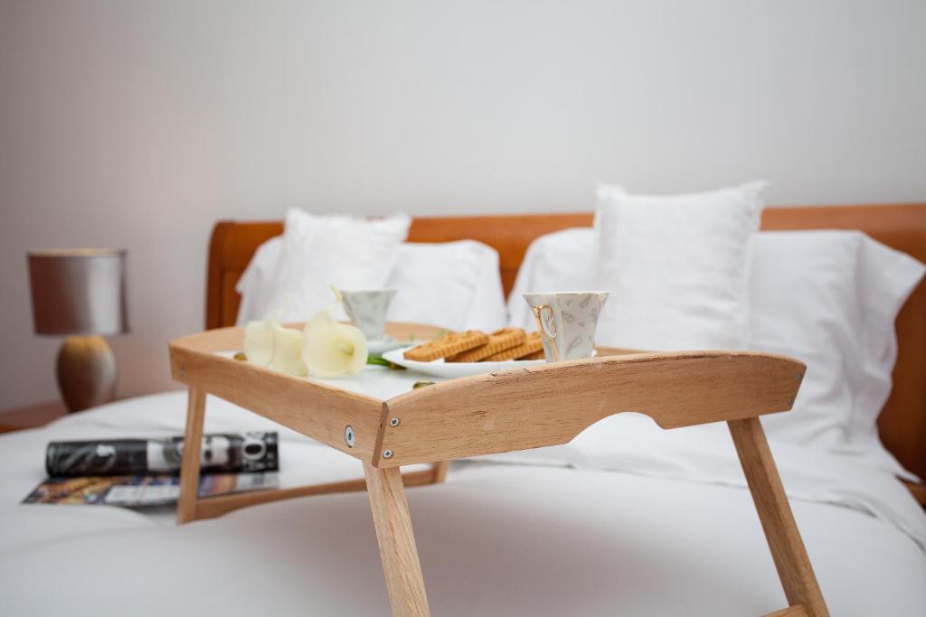 a wooden tray with a plate of food on a bed at BeGuest Cascais Inn Apartments in Cascais