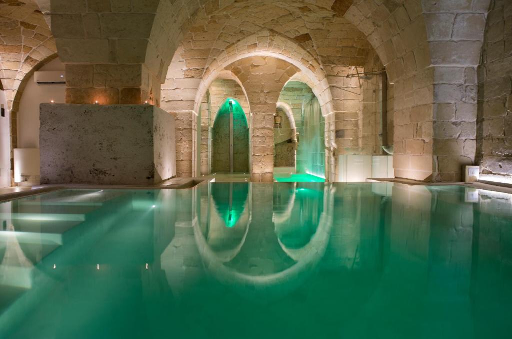 a swimming pool in a building with green lights at ReLuxe Private Wellness in Lecce