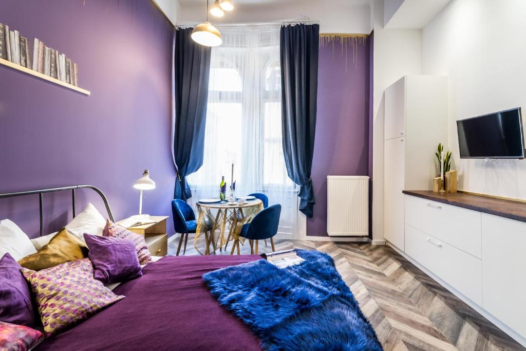 ブダペストにあるThe purple - studio apartment in the centre of Budapestの紫色のベッドルーム(ベッド1台、テーブル付)