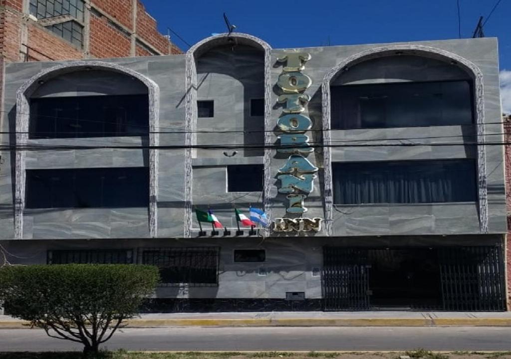 un bâtiment avec des drapeaux sur son côté dans l'établissement Totorani Inn, à Puno