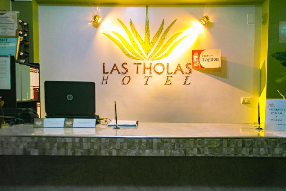 een bord voor een winkel met een laptop op een toonbank bij Las Tholas Hotel in Uyuni