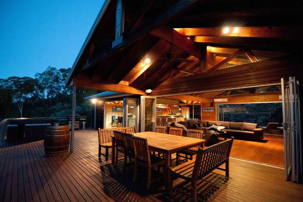 a wooden deck with a wooden table and chairs at Milbrodale Lodge in Broke