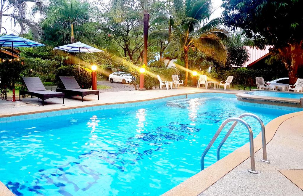 a swimming pool with chairs and umbrellas in a resort at Mild Garden View Resort in Ao Nang Beach