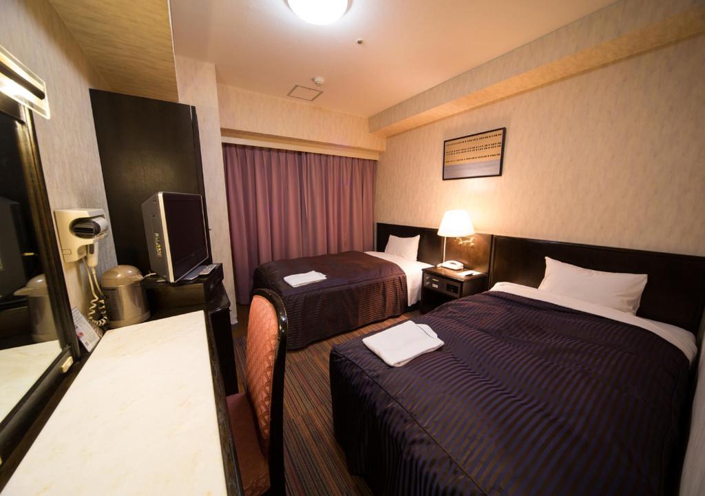 Postel nebo postele na pokoji v ubytování Hotel Claiton Esaka
