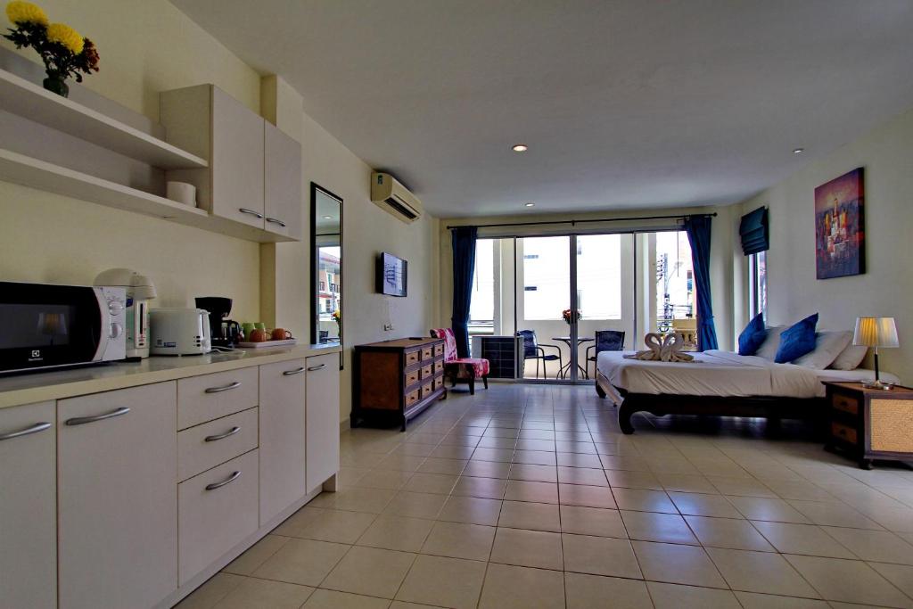 a kitchen and living room with a bed and a couch at The Green House in Kata Beach