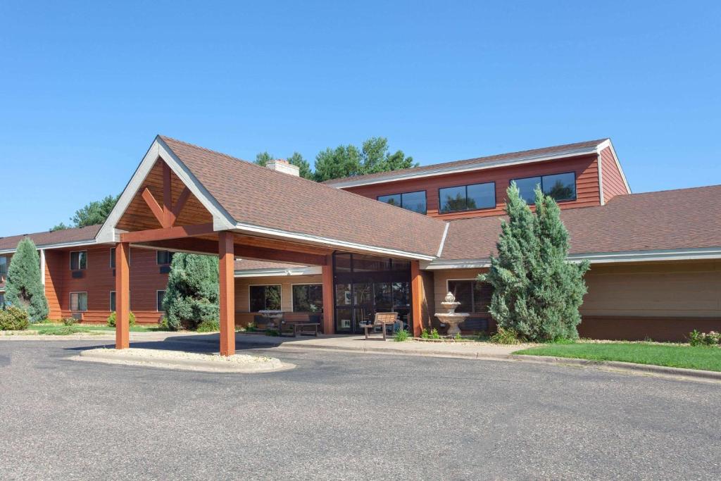 a large house with a gambrel roof at AmericInn by Wyndham Ham Lake in Ham Lake