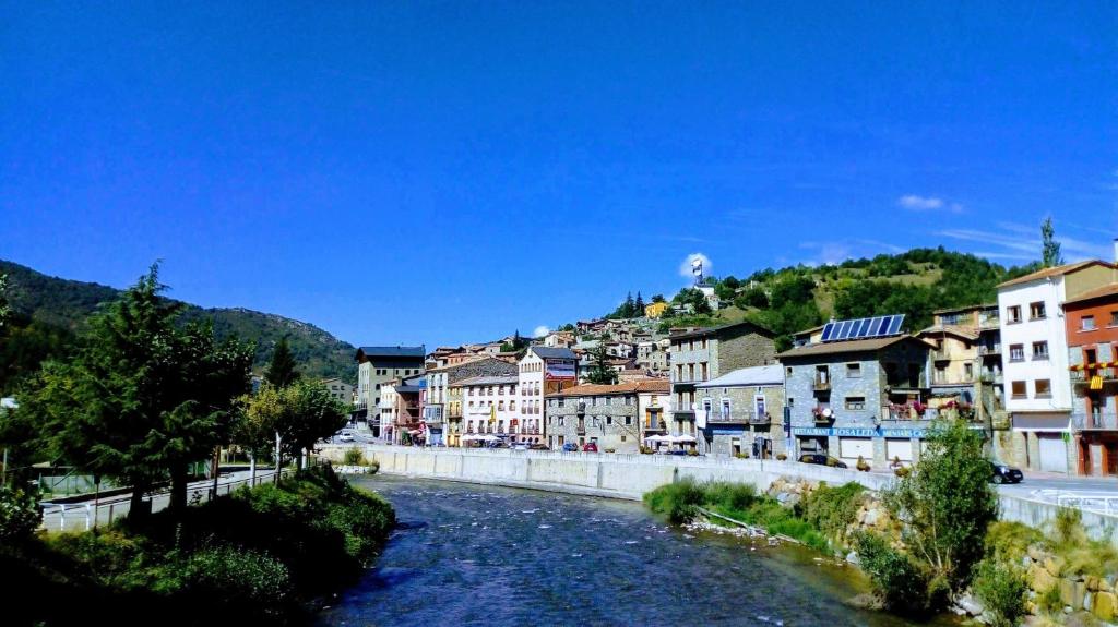 a river in a town with houses and buildings at Cal Martí in Martinet