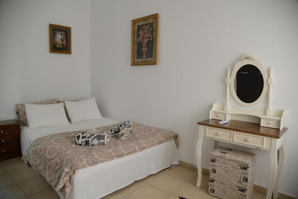 um quarto com uma cama, uma cómoda e um espelho em Hermes Apartment -1 em Nafplio