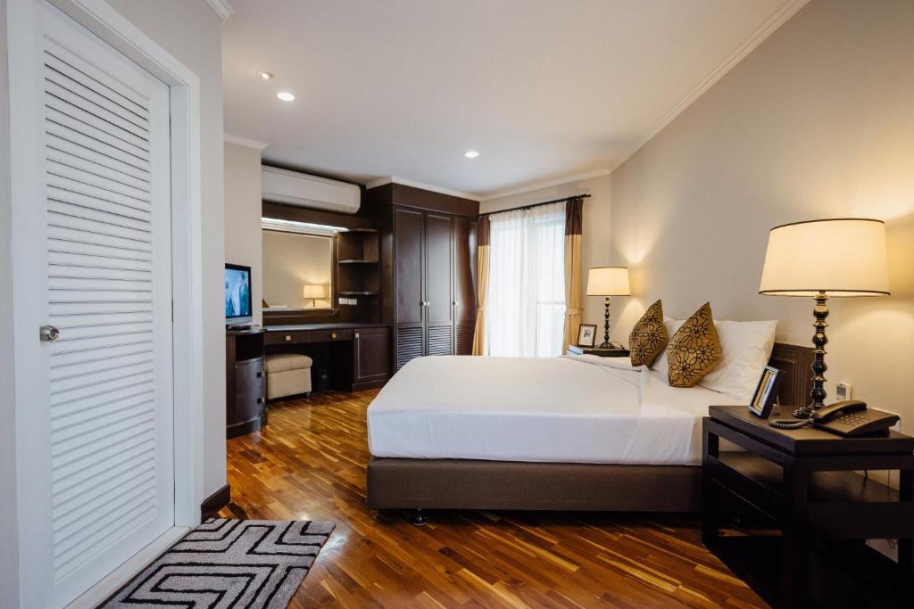 バンコクにあるCNC Residenceのベッドとテレビが備わるホテルルームです。