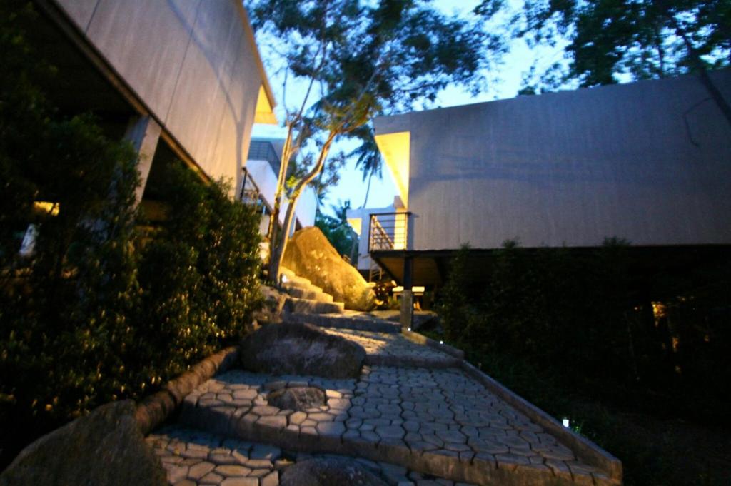 a stone walkway in front of a building at night at Matina Mountain Resort in Koh Tao