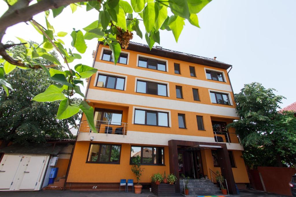 um edifício laranja e branco com janelas em Hotel Anna em Târgu Jiu