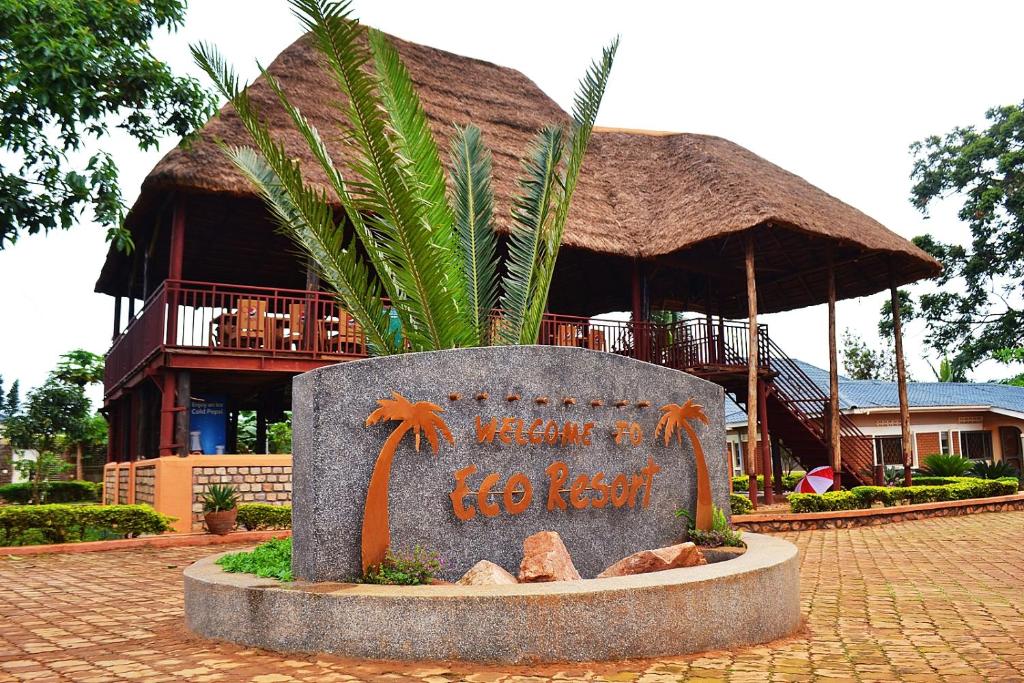 un cartello di fronte a un edificio con una capanna di Eco Resort Kasenyi a Entebbe