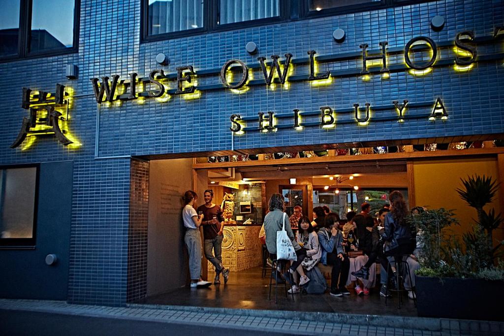 een groep mensen die buiten een winkel staan bij Wise Owl Hostels Shibuya in Tokyo