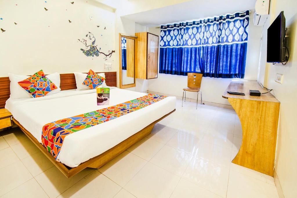 a hotel room with a bed and a television at FabExpress Karishma Rasta Peth in Pune