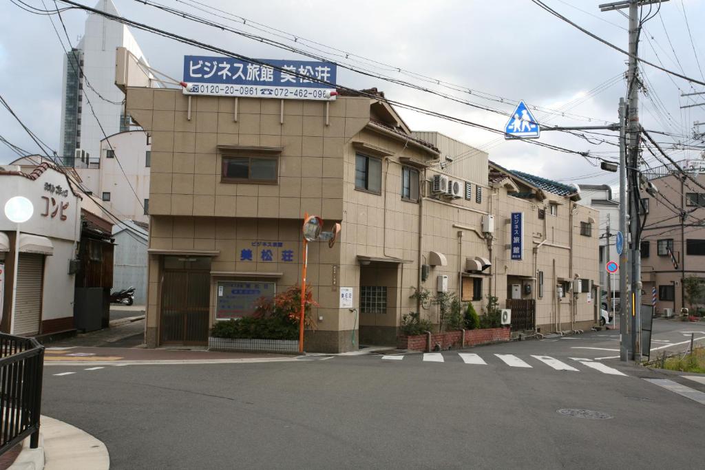 a building with a sign on the side of a street at Mimatsuso in Izumi-Sano