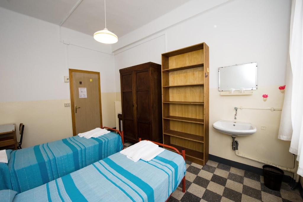 Postel nebo postele na pokoji v ubytování Ostello Domus Civica