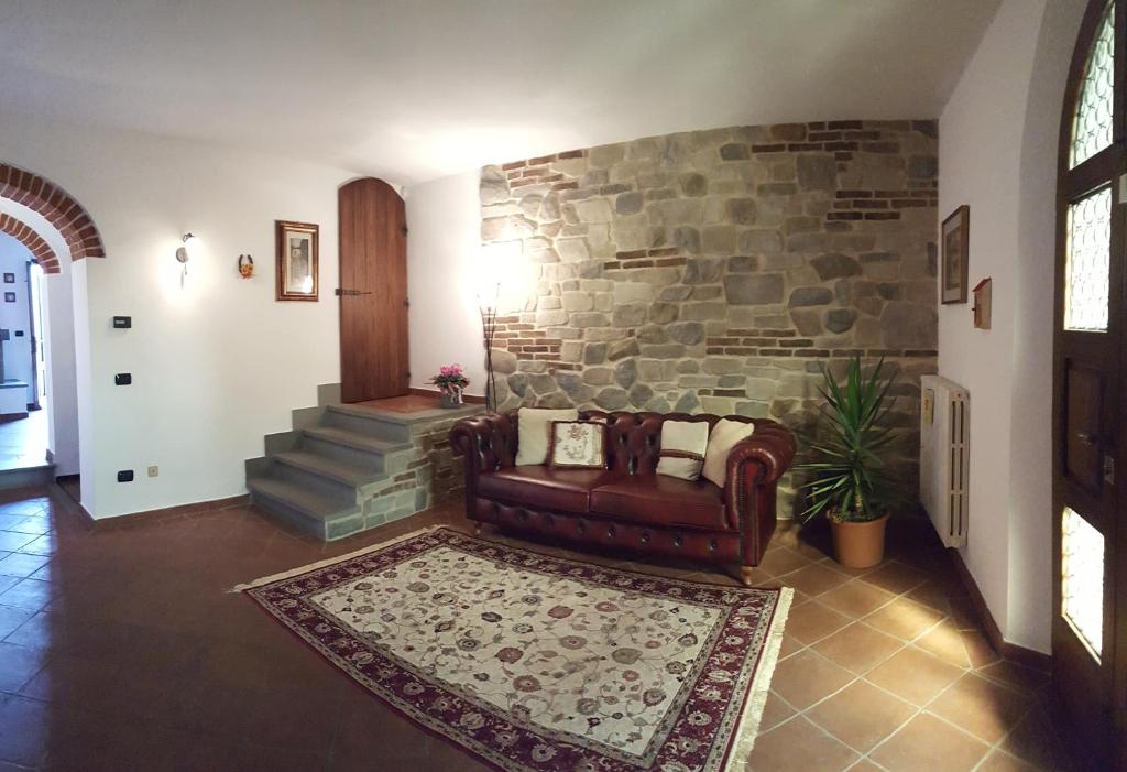 Casa Leonardo في كوارّاتا: غرفة معيشة مع أريكة وجدار حجري