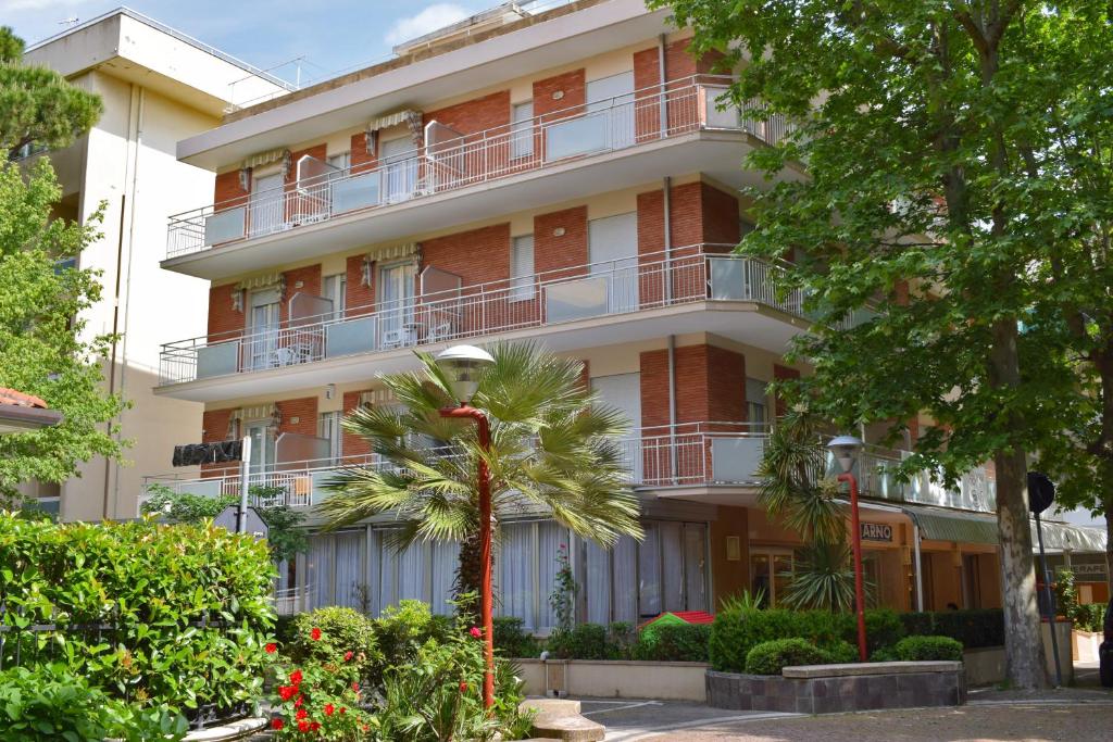un edificio con una palmera delante de él en Hotel Arno, en Misano Adriatico