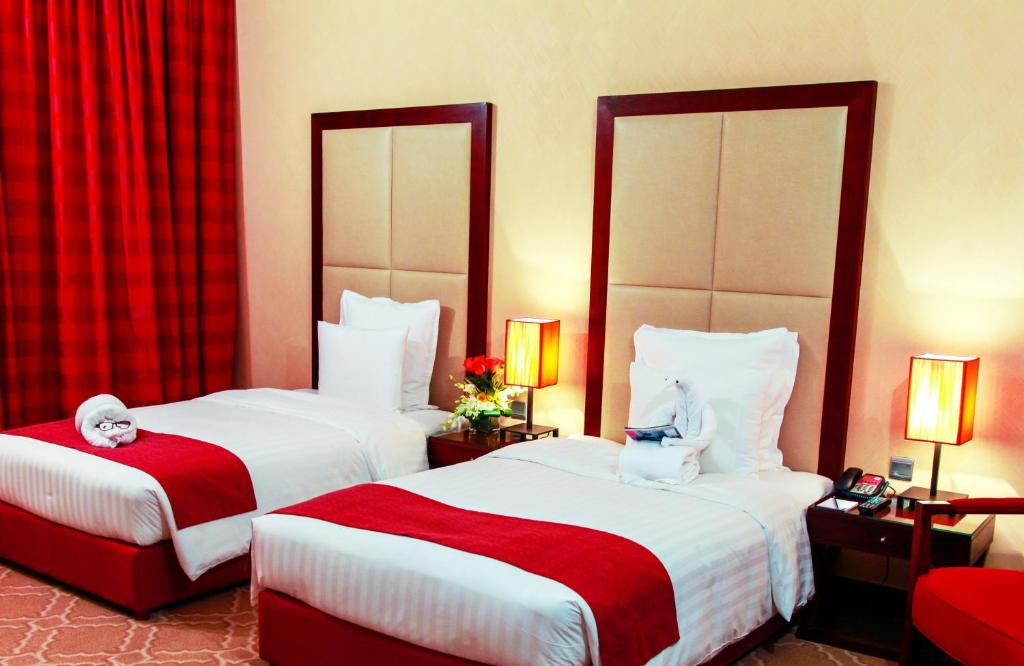 Postel nebo postele na pokoji v ubytování Grand Regal Hotel