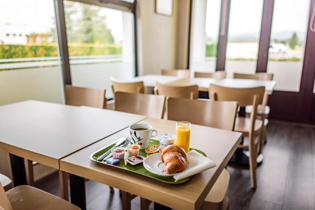 ベルフォールにあるB&B HOTEL Belfort Bessoncourtのレストランのテーブルに並ぶ朝食用の食材
