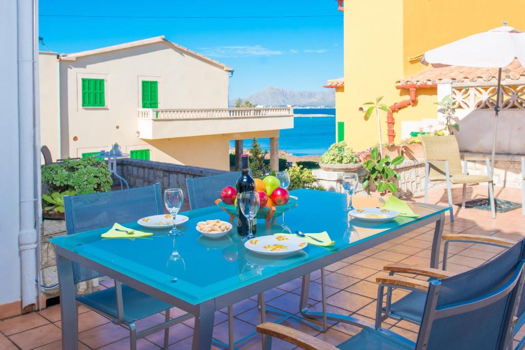 einen blauen Tisch auf einer Terrasse mit Meerblick in der Unterkunft Xarus 2 in Alcúdia