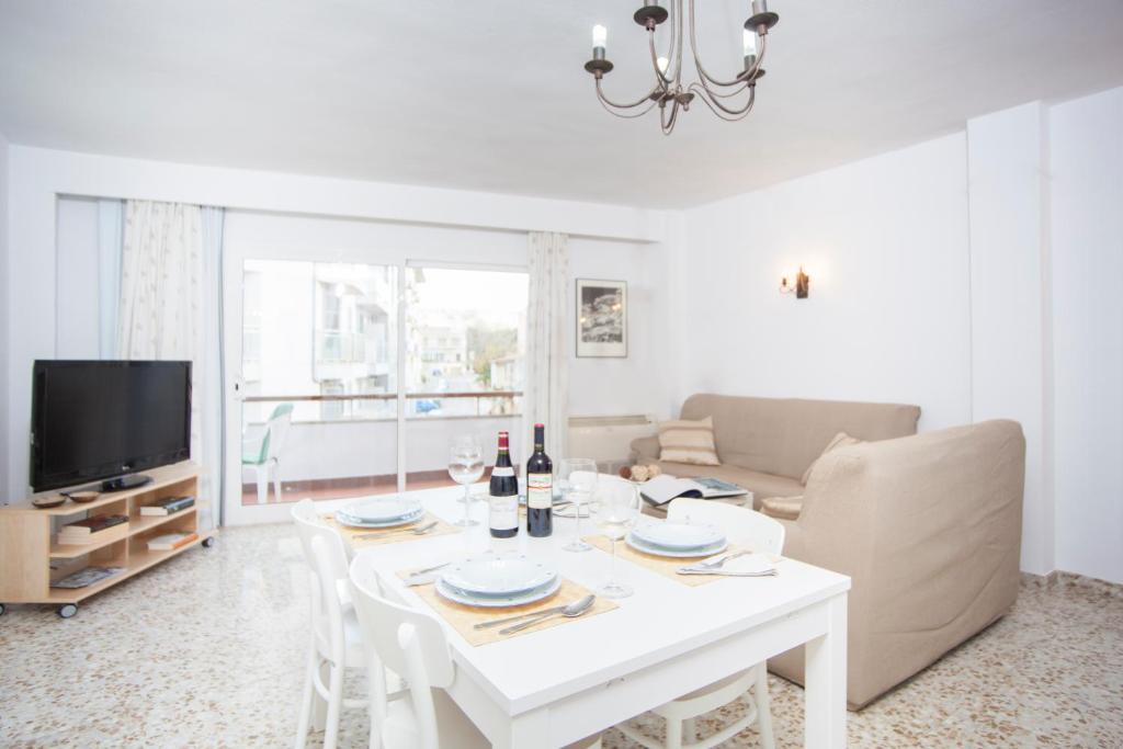 a living room with a white table and a tv at Curling in Port d'Alcudia