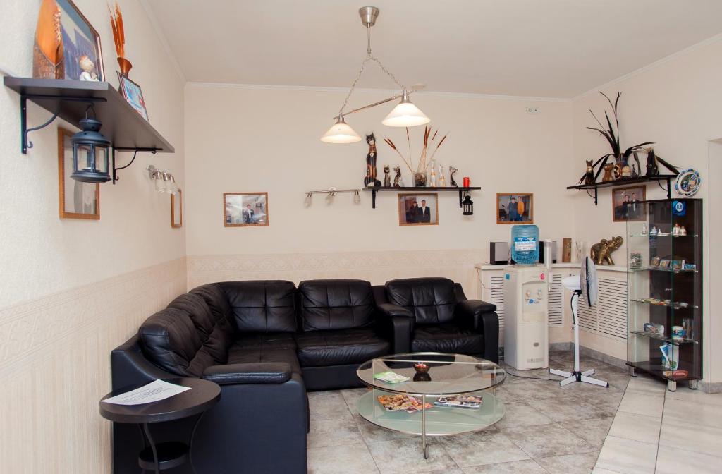 sala de estar con sofá de cuero y mesa en Style Hotel en Lipetsk