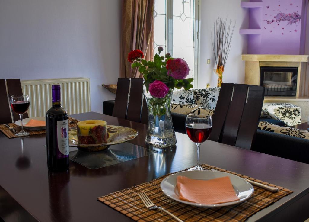 a table with a plate of food and a glass of wine at ANEMOS HOLIDAYS HOUSE in Kipseli