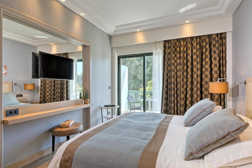 a bedroom with a large bed and a large window at Rodos Park in Rhodes Town