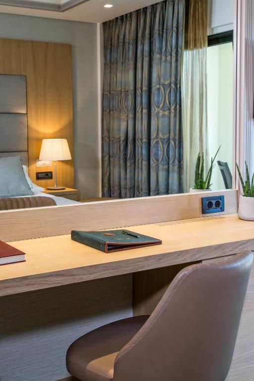 a hotel room with a desk with a book on it at Rodos Park in Rhodes Town