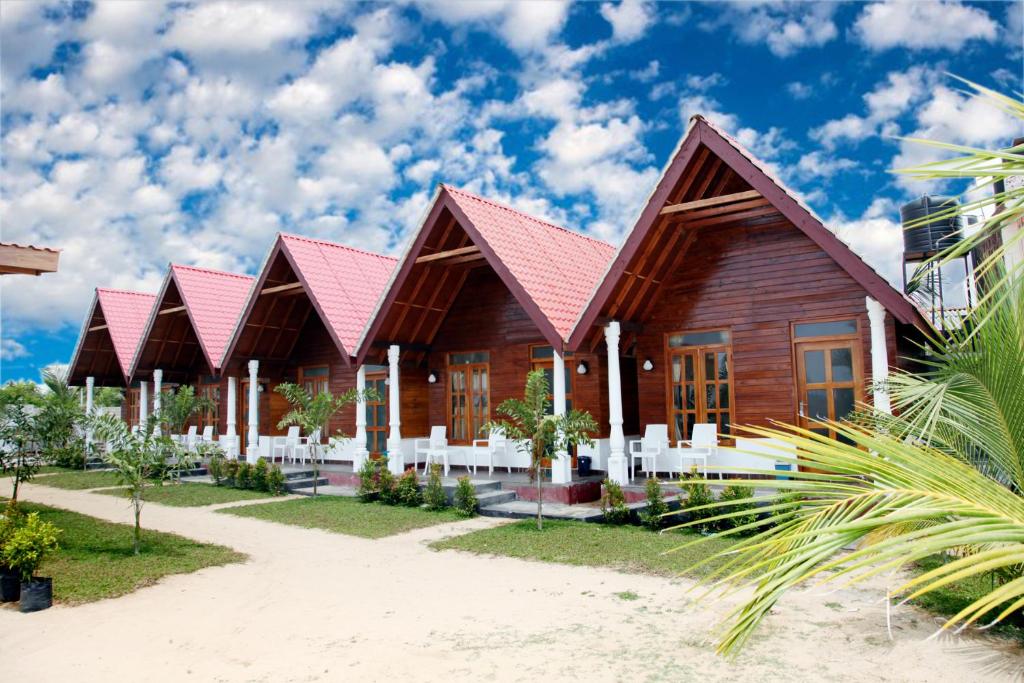 una casa con techo rojo en una playa en Elegant Green Beach Resort en Trincomalee