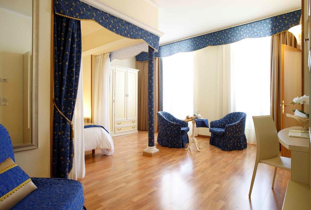 a living room with blue chairs and a mirror at Residence Liberty in Trieste