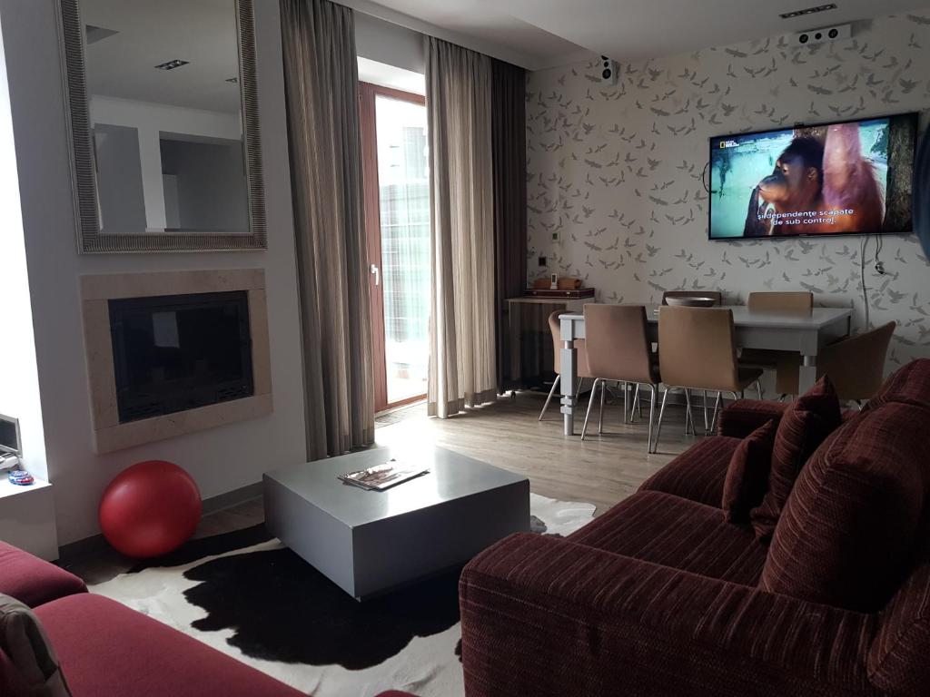a living room with a couch and a tv on the wall at Apartment Poiana Brasov in Poiana Brasov