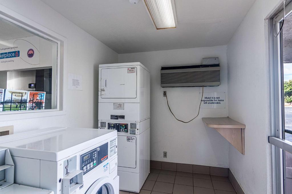 a laundry room with a washer and dryer and a window at Motel 6-Ardmore, OK in Ardmore