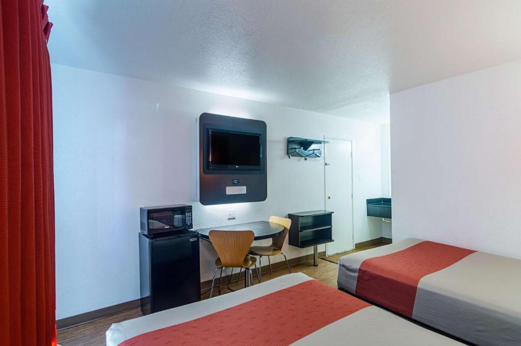 a hotel room with a desk and a tv on the wall at Motel 6-Ardmore, OK in Ardmore