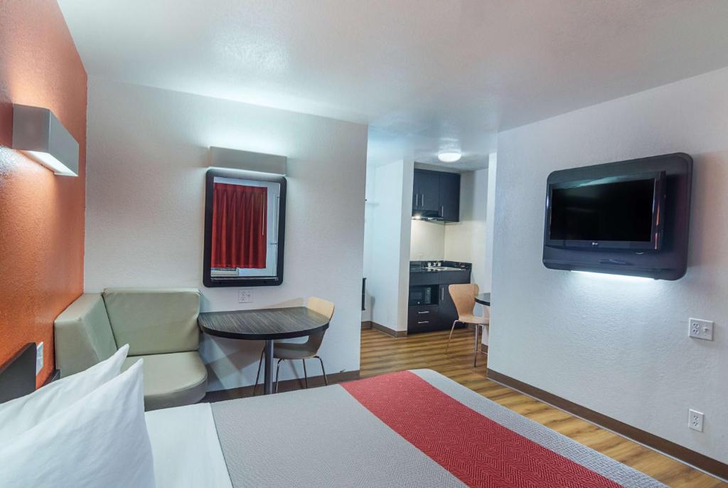 a hotel room with a bed and a small table and a television at Motel 6-Ardmore, OK in Ardmore