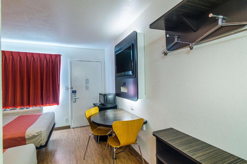 a small room with a bed and a table and chairs at Motel 6-Ardmore, OK in Ardmore