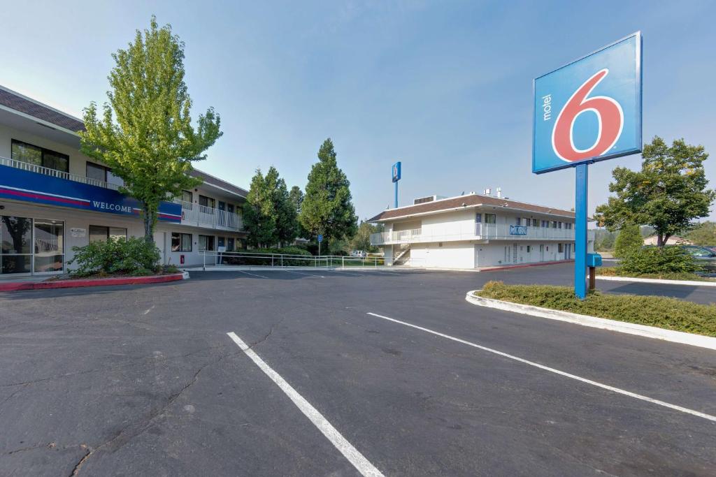 an empty parking lot in front of a building at Motel 6 Weed - Mount Shasta in Weed