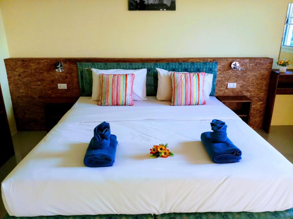 Una cama con dos zapatos azules y flores. en Bangtao Mango House, en Bang Tao Beach