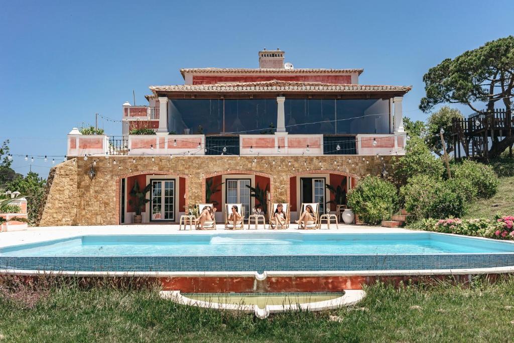 una casa con piscina frente a ella en Dreamsea Surf Guest House en Sintra