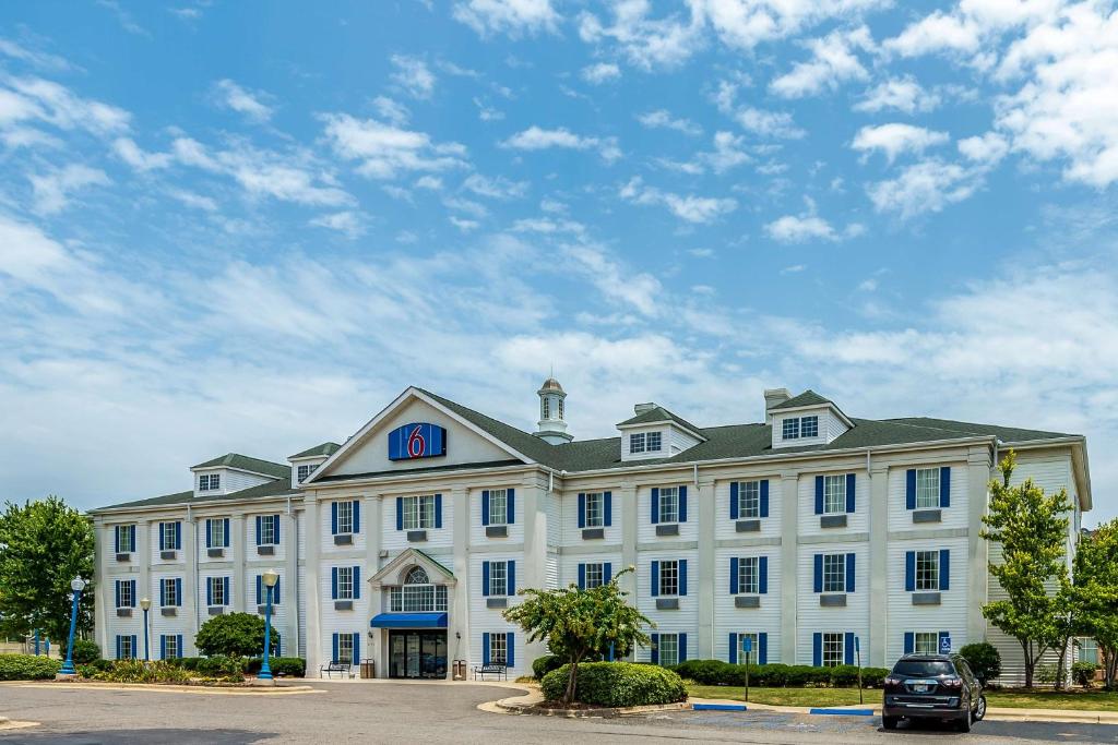 a large white building with a car parked in front of it at Motel 6-Shreveport, LA in Shreveport