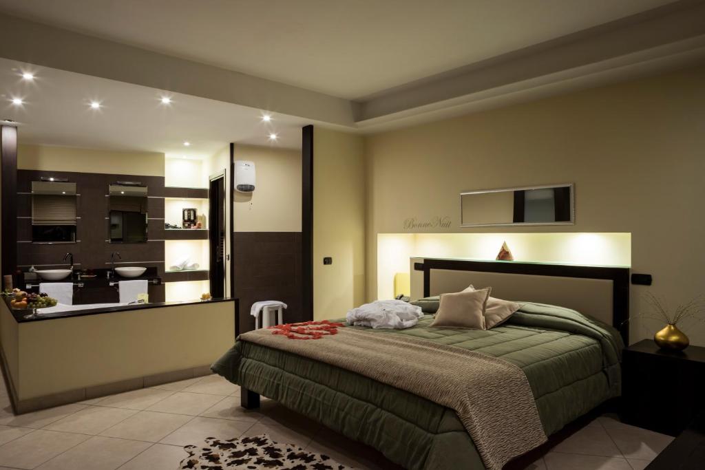 a bedroom with a bed and a view of a kitchen at Manhattan Village Hotel in Sulmona